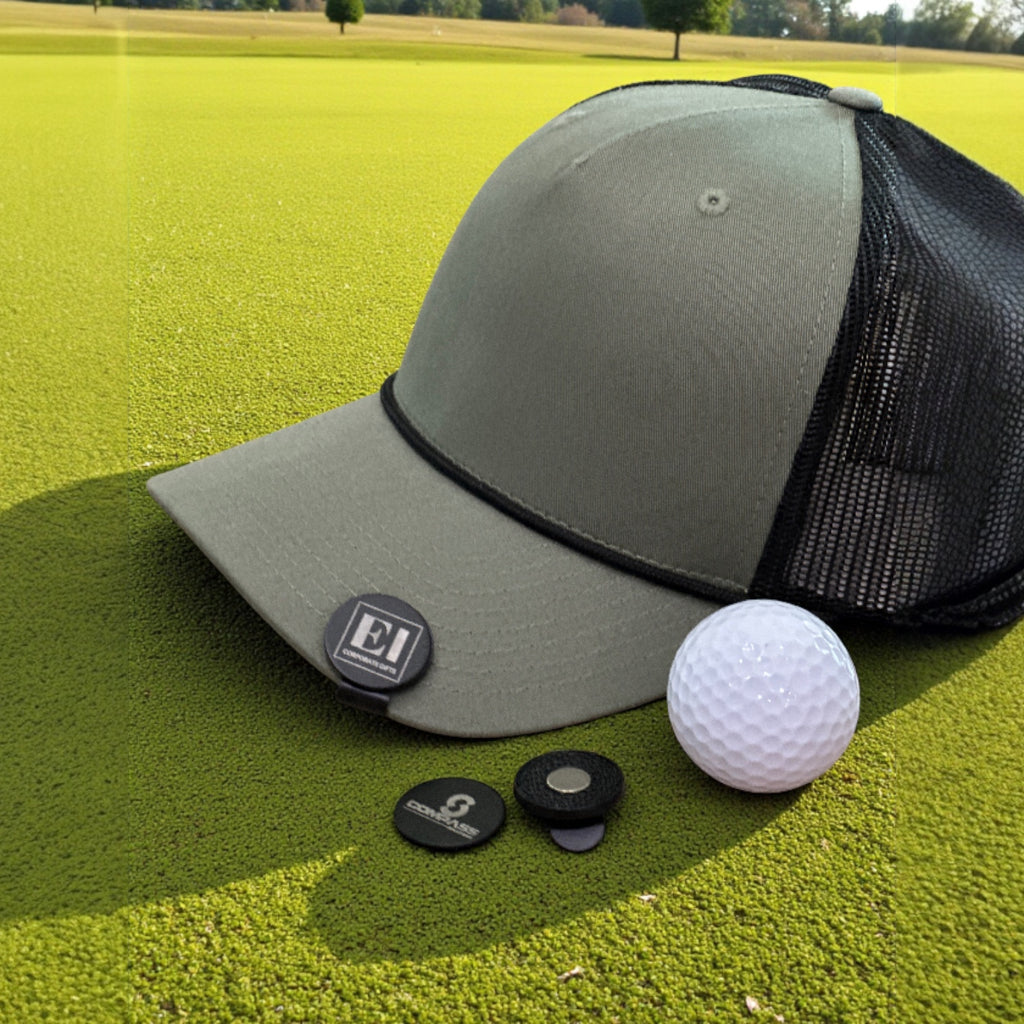 Customized golf marker hat clip with magnetic closure shown outdoors in natural light. Perfect for golfers, companies, and events looking for practical and memorable gifts. Laser engraved personalization highlights logos, initials, or tournament branding.