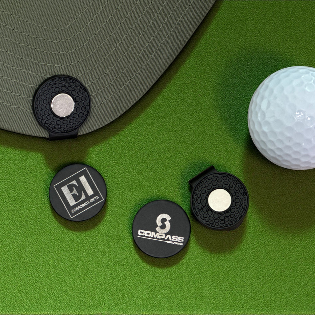 Customized golf marker hat clip with magnetic closure shown outdoors in natural light. Perfect for golfers, companies, and events looking for practical and memorable gifts. Laser engraved personalization highlights logos, initials, or tournament branding.
